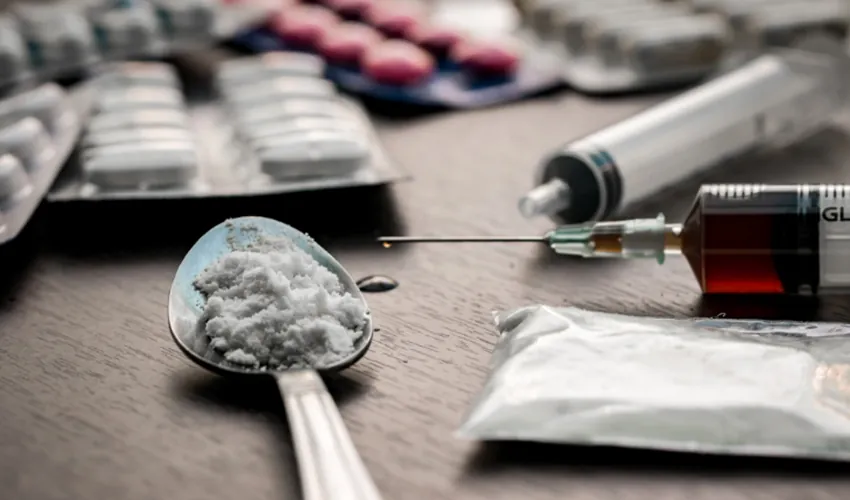 Drugs, pills and a syringe on a table